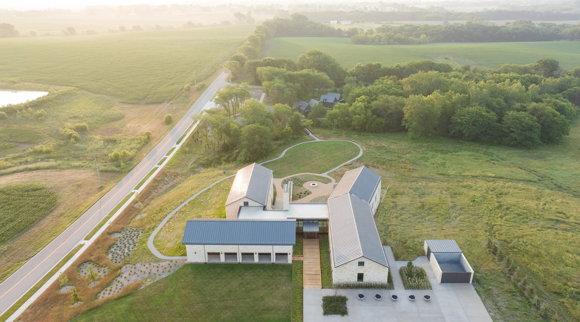 Focal Herzog Foundation aerial view metal gable roofs limestone walls wood decking landscaped path prairie